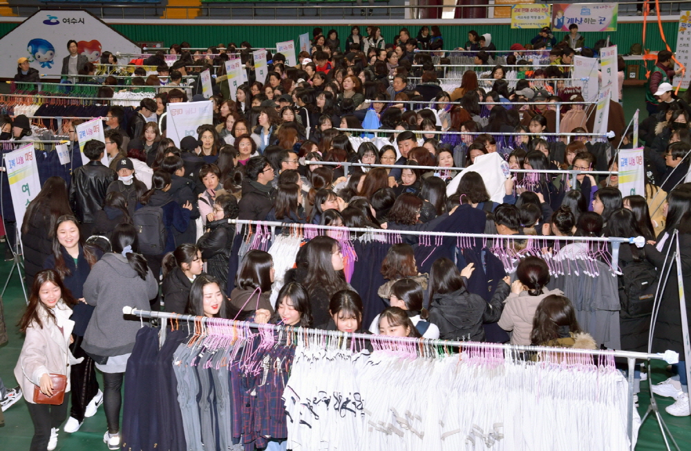 21일 오전 중‧고등학교 교복 물려주기 행사에 참여한 학생과 학부모가 진열 상품을 둘러보고 있다.