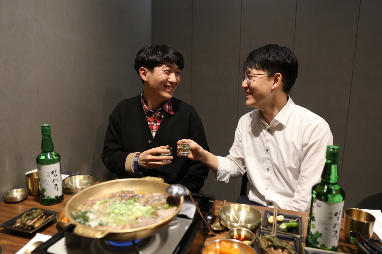 젊은잎새 봉사단 1기 회장이었던 황복연 씨(오른쪽)가 9기 회장이었던 김경일 씨와 잎새주를 마시며 이야기를 나누고 있다