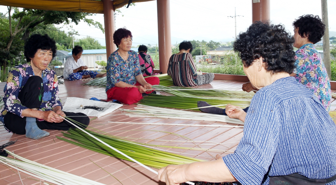 5대째 전통방식으로 왕골돗자리를 생산하고 있는 전남 함평군 월야면 용월리 정일범 씨를 도와 왕골 박피 작업을 하고 있는 용월리 외세마을 주민들.