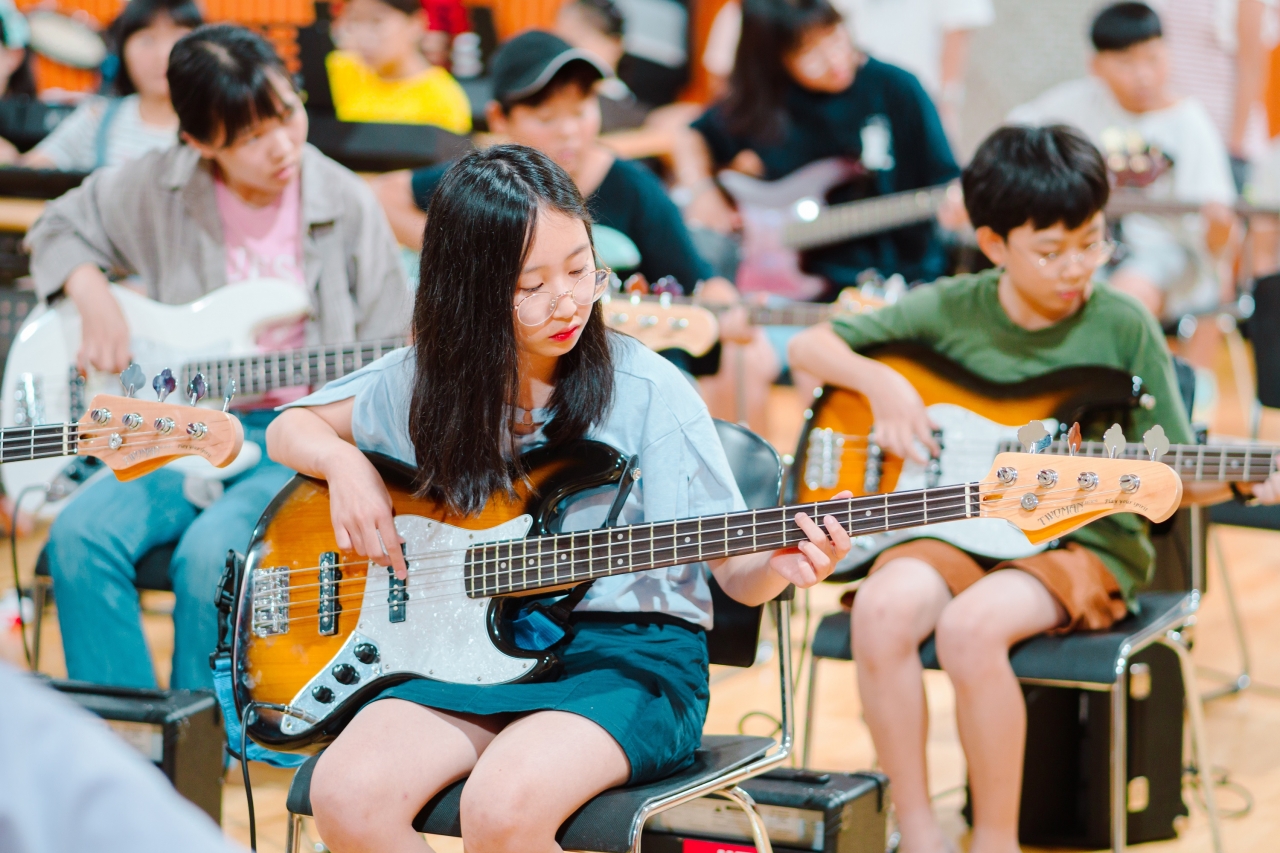 GS칼텍스 ‘희망에너지캠프’에 참여한 학생들이 기타 연주를 배우는데 열중하고 있는 모습.