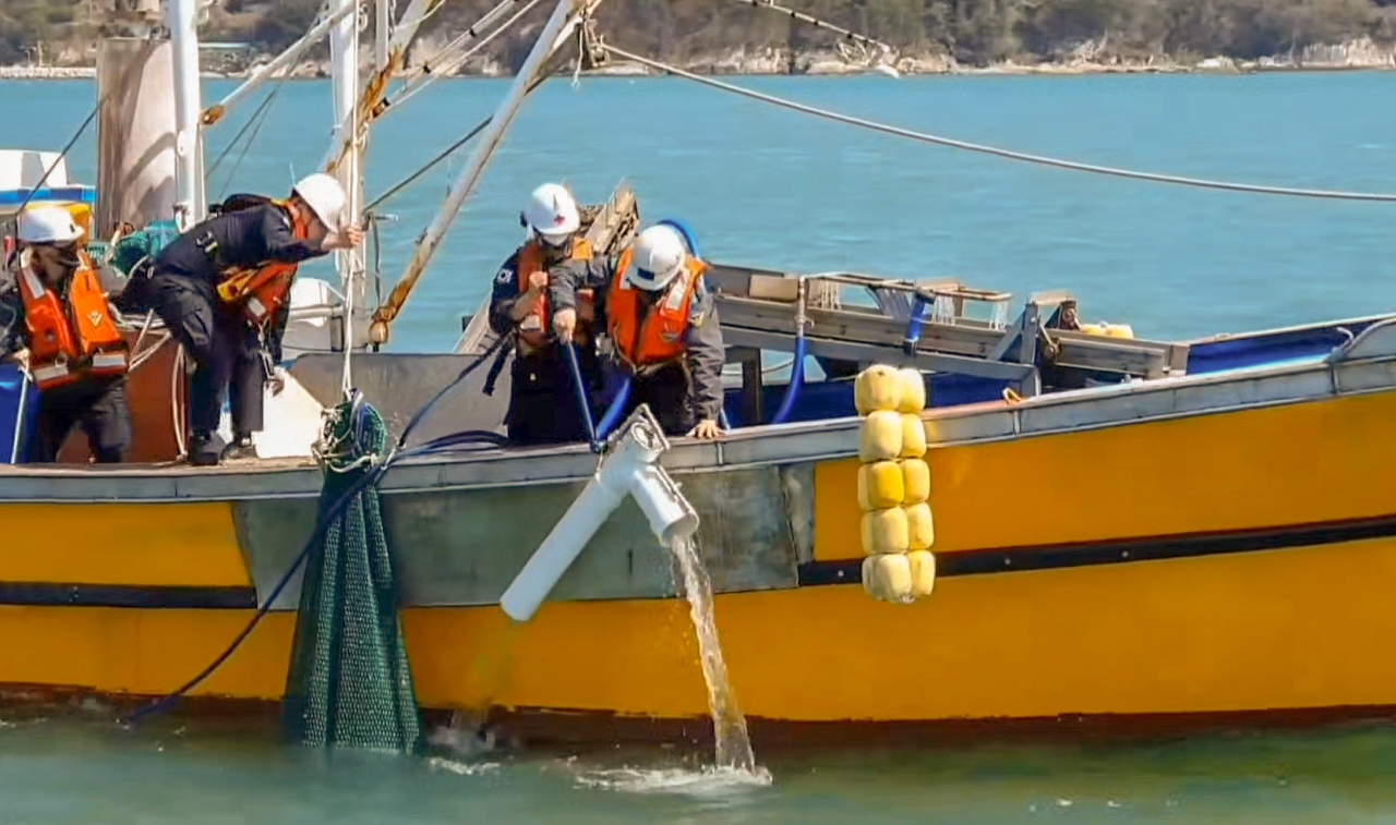 적발된 어선에서 갯벌속 조개들을 채취하기 위해 사용한 수중흡입장비를 해양경찰관들이 확인하고 있다.